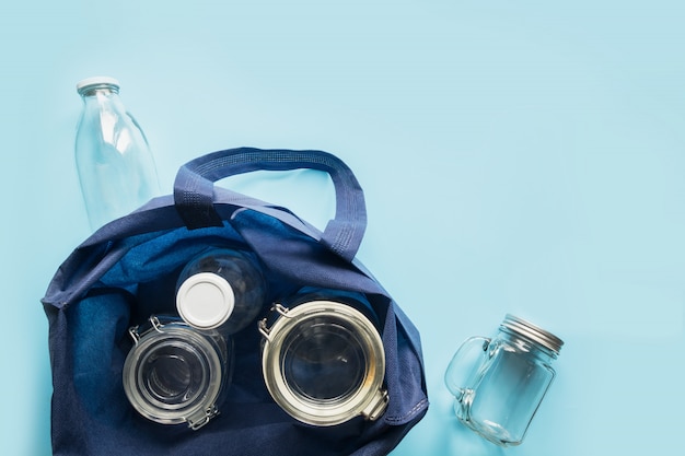 Set of jars and textile bag on blue.