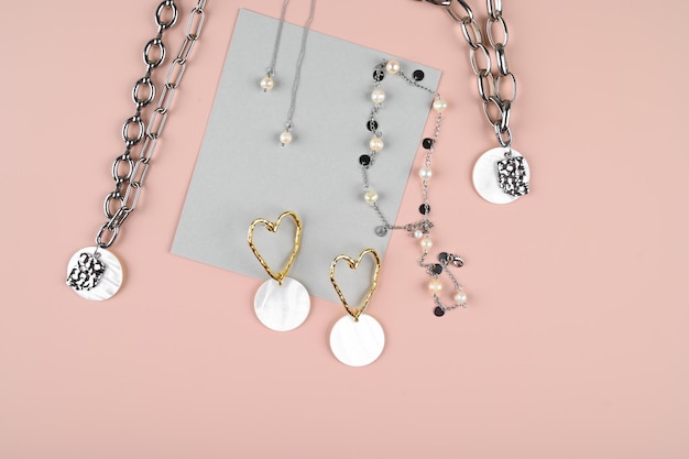 Set ketting chokers met parels oorbellen op roze oppervlak Trendy stijlvolle sieraden Female blog