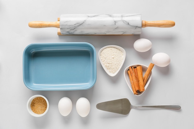 Set of kitchen utensils and ingredients for preparing bakery on light background