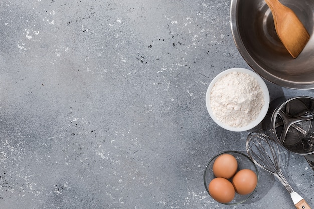 Set di utensili da cucina con prodotti su sfondo grigio-blu. corsi di perfezionamento di cucina. copia spazio.