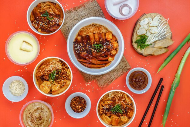 A set of Korean food and sweet drink is served on the orange background.