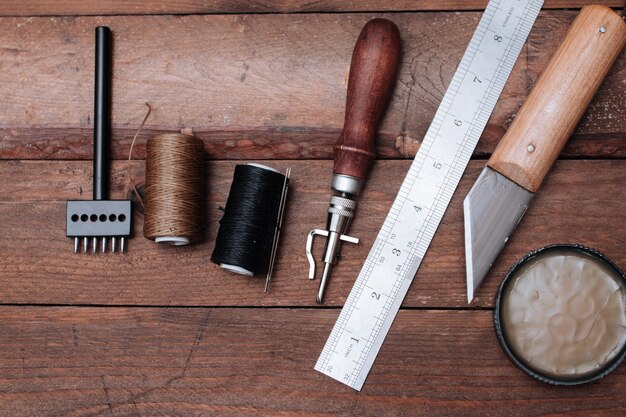 Set lederen knutselgereedschappen. schoenen maker tools op houten tafel.