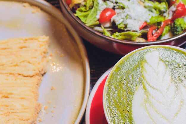 Foto un pranzo fisso giapponese su un tavolo in un ristorante include salmone grigliato, insalata arcobaleno, tè matcha, fagioli di soia verdi