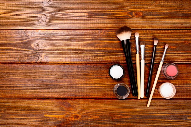 Set make-up kwasten en matte oogschaduw en blozen op houten achtergrond