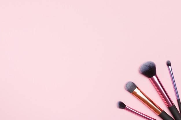 Set of makeup brushes on a pink background