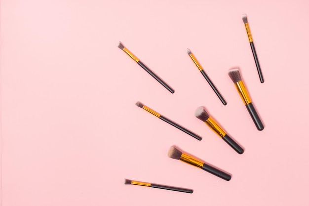 Set of makeup brushes on pink background