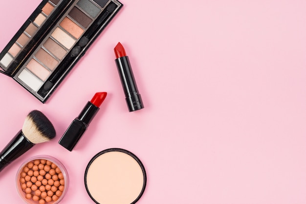 Set di trucco e accessori cosmetici su sfondo rosa