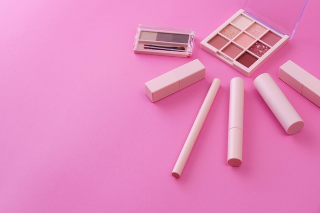 A set of makeup tools and a pink background