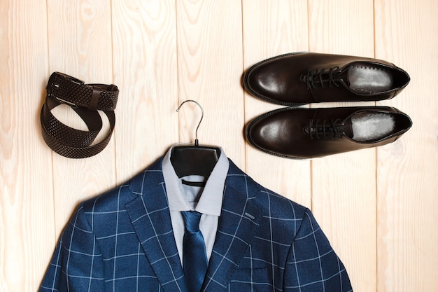 Foto set di abbigliamento maschile. cintura scarpe giacca in legno chiaro.