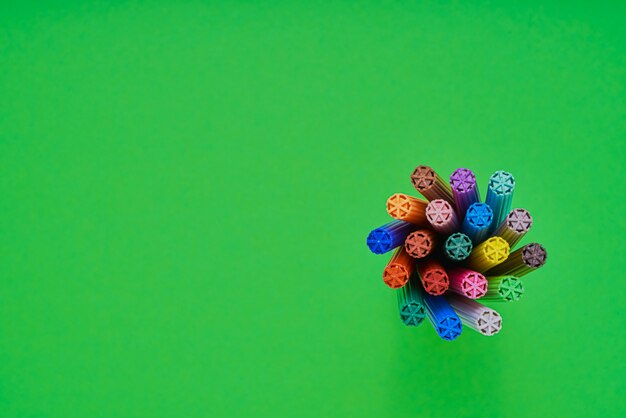 Set of markers in a holder and on bright green neon background. Top view. Back to school concept