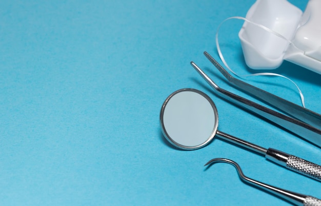 Set of medical dental equipment and dental floos on blue background Copy Space