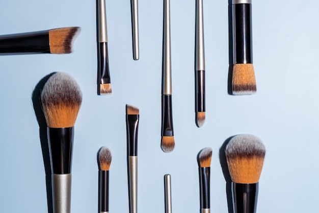 Set met verschillende make-upborstels voor het aanbrengen van cosmetische producten op blauwe achtergrond