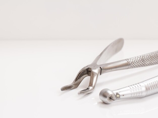 Photo set of metal dental instruments for dental treatment on the white background medical tools