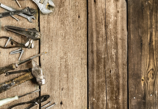 Una serie di strumenti di metallo in officina su un vecchio concetto di fondo in legno rustico festa del papà