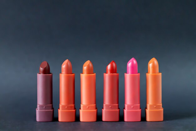 Set mode lippenstiften palet in rode, bruine en roze kleuren, studio foto op zwarte achtergrond. Mooi make-up of cosmetisch verkoopconcept