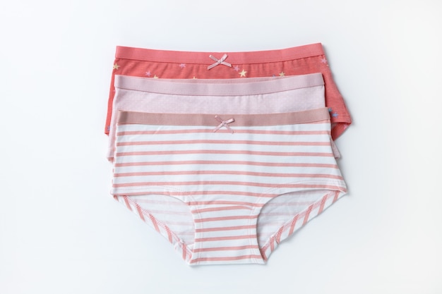 Foto set di mutandine per bambini in cotone multicolore, biancheria intima per ragazze su sfondo bianco. vista dall'alto, copia spazio, disposizione piatta, primo piano. concetto di abbigliamento per bambini, organizzazione del guardaroba. orizzontale.