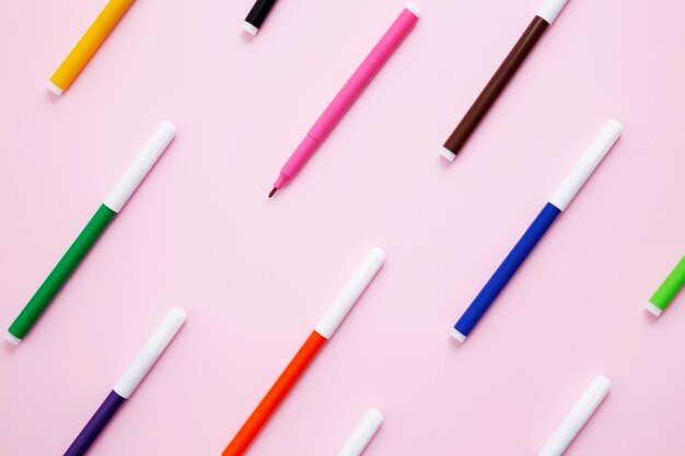 Set of multicolored felttip pens on pink background Back to school Flat lay