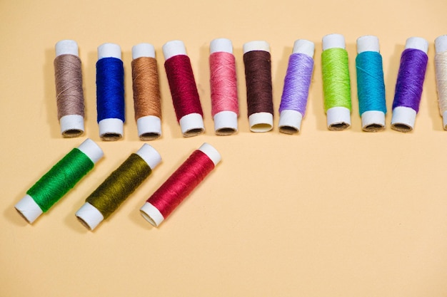 A set of multicolored threads for sewing with an empty space for text