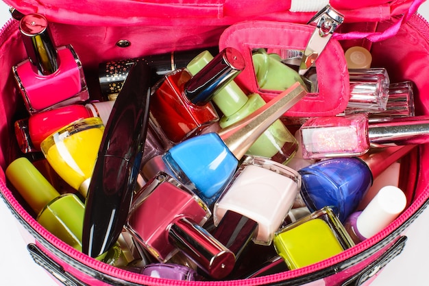 Set of nail polish, mascara, nail clippers, in a pink purse