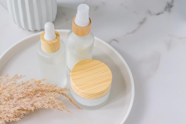 Set of natiral organic cosmetics on a cereamic tray with dry pampas grass boucuet Skandinavian style decor Nordic cosmetics