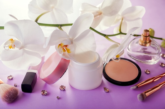 Foto set di cosmetici naturali e pennelli trucco con orchidea bianca