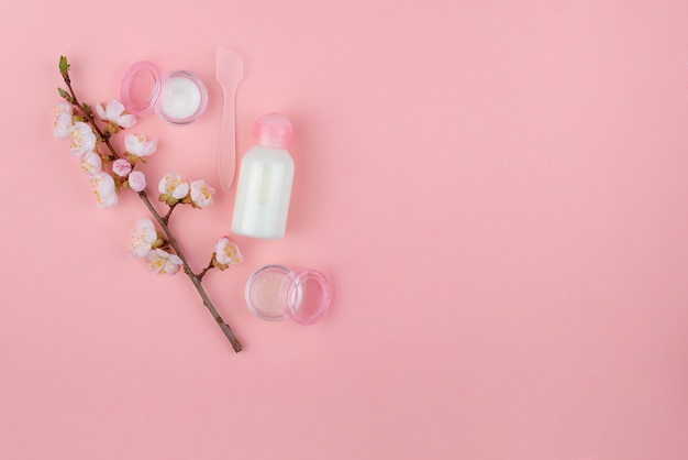 Set of natural cosmetics and Spa products on a pink wall. Flat lay with space for text.