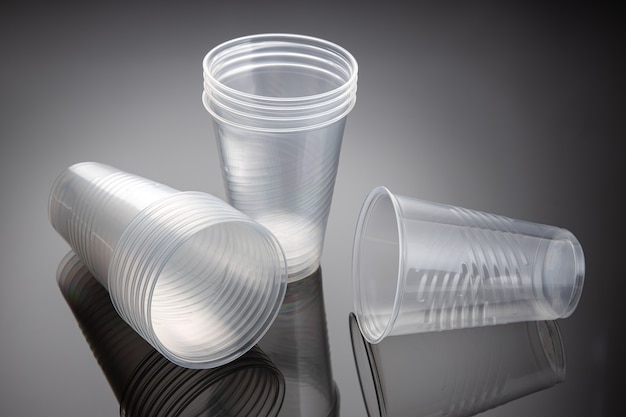 Foto set di nuovi bicchieri di plastica vuoti. rifiuti di plastica usa e getta. avvicinamento