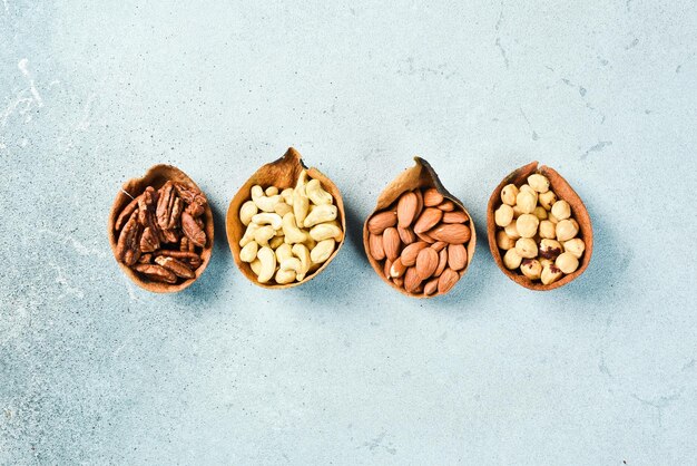 a set of nuts in a bowl on a light stone background Healthy snacks Nuts