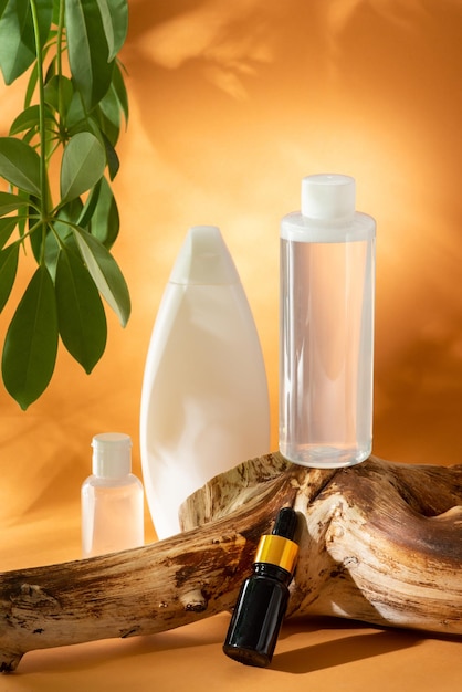 Фото Набор чистой белой бутылки шампуня, геля для душа, кремов для тела, масла для лица и тоника на оранжевом фоне