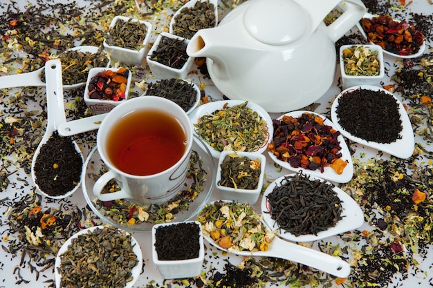 Фото Набор различного чая в мисках на белом фоне