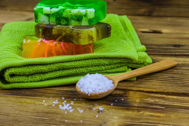 Фото Набор ручных мыльных батончиков с морской солью и полотенцем на деревянном фоне spa концепция