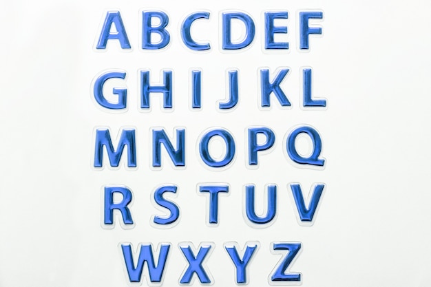 写真 光沢のある青い光沢のある文字のセット、白い背景で隔離。英語のアルファベットabcの記号。