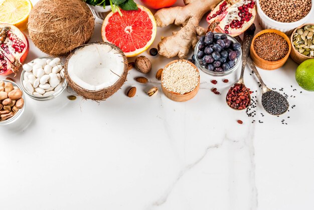 Set of organic healthy diet food, superfoods - beans, legumes, nuts, seeds, greens, fruit and vegetables.. white background copy space. top view