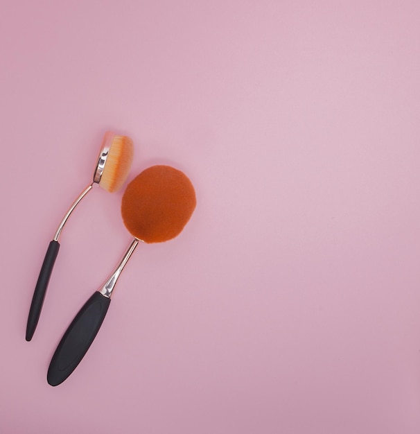 Photo set of oval brushes for makeup on pink background