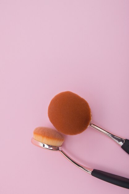 Set of oval brushes for makeup on pink background