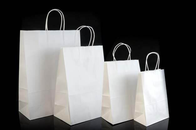 Set of paper bags for shopping on black background Mockup for design