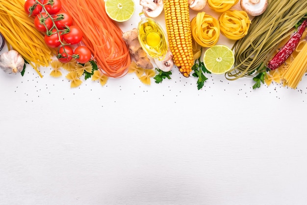 Set of pasta noodles spaghetti Italian cooking fresh vegetables and spices On a white background Top view Copy space