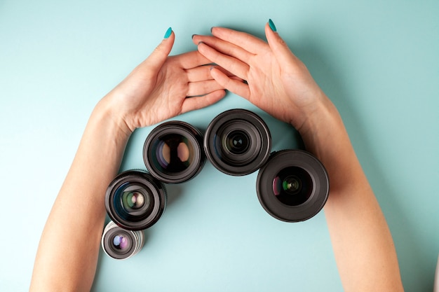 Set of photo lenses, the selection and comparison of photographic equipment, hands are holding photo equipment