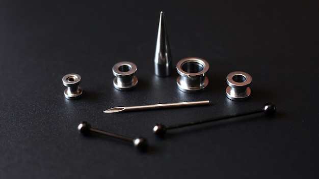 Set for piercing on a dark, ear tunnels, tunnels and earrings\
for the ears and tongue close up.