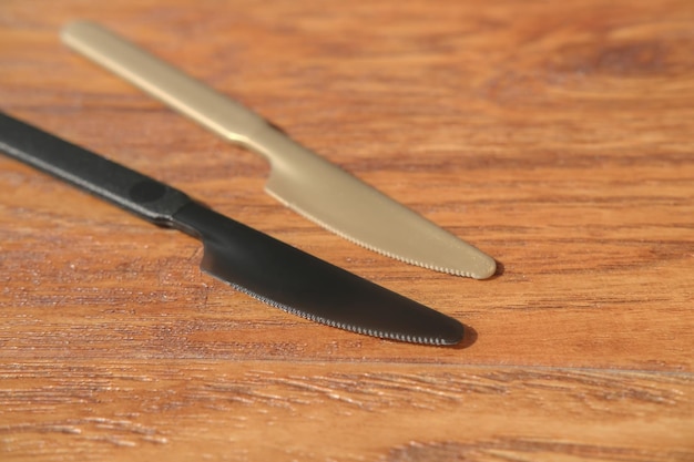 Photo set of plastic knives on a wooden table