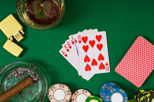 Set to playing poker with cards and chips on green table, top view. Still life