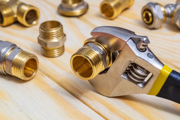 Set plumbing fittings and adjustable spanner on wooden boards after repair or replacement of spare parts