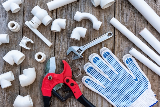 set of polypropylene pipes, gloves, and pipe cutter