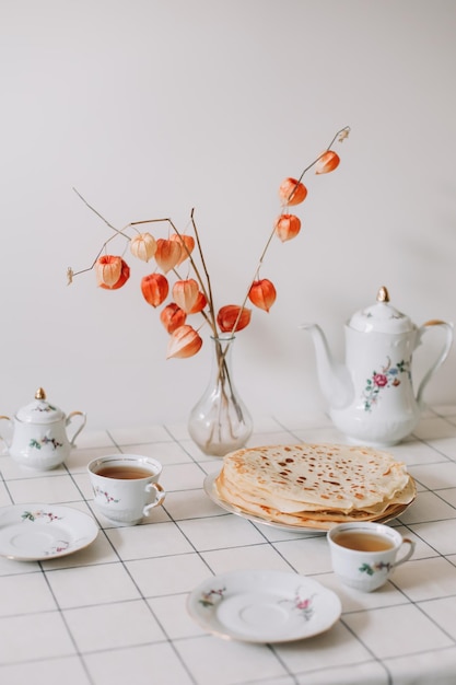 A set of porcelain coffee and tea set with cups mugs and plates on a table