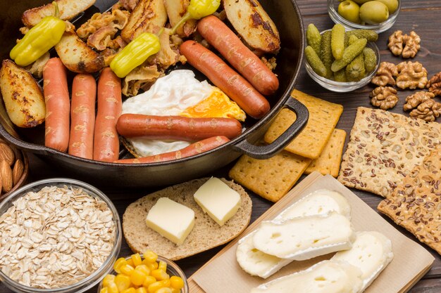 Set di prodotti per una colazione equilibrata: salsicce di patate, frutta a guscio, biscotti al burro.