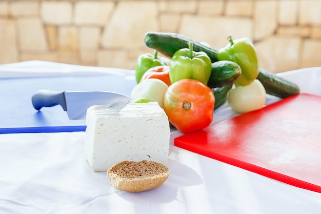 Set of products for a Greek salad on the table with knife and cutting board