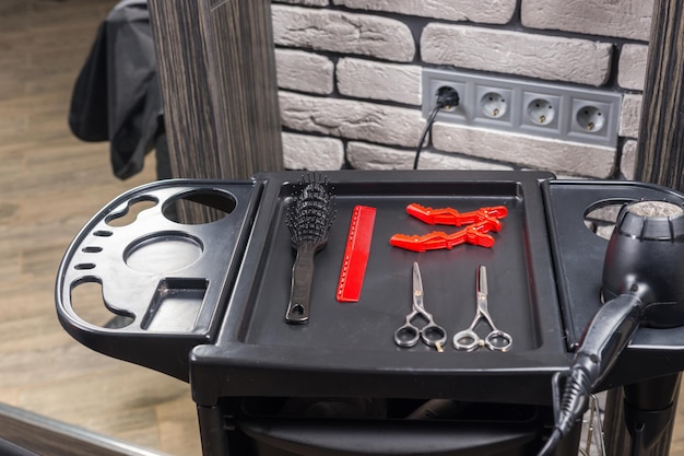 Set di strumenti professionali per parrucchieri su un supporto speciale nel salone di bellezza
