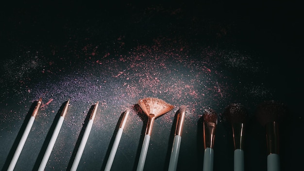 Set of professional makeup brushes on black background