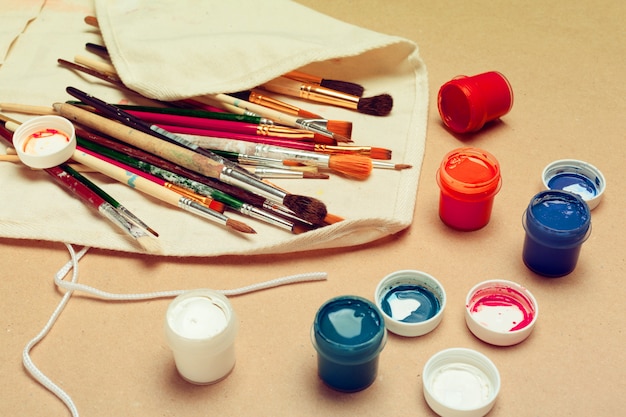 Set of professional watercolor artist brushes in a  hand made roll case and watercolor paints close up