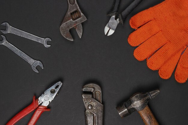 Set of professional work tools on black background. Top view. Copy space